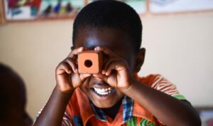 Young kid looking through a block